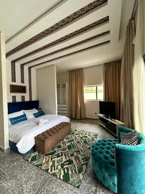 a bedroom with a large bed and a blue chair at Villa akiba in Marrakech