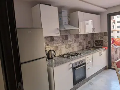 a kitchen with white cabinets and a refrigerator at Bel appartement au cœur de Marrakech in Marrakech