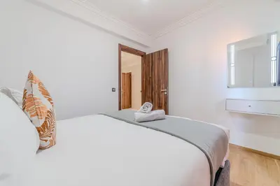 a white bedroom with a large bed and a window at Central Gueliz 2 min M Avenue Balcony Pool View in Marrakech