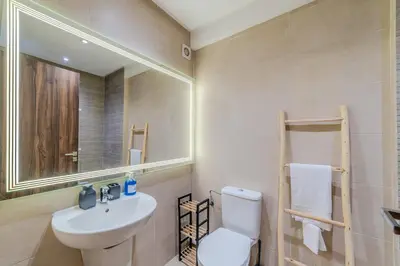a bathroom with a sink and a toilet and a mirror at Central Gueliz 2 min M Avenue Balcony Pool View in Marrakech