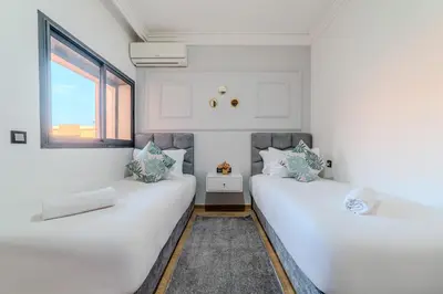 two white beds in a room with a window at Central Gueliz 2 min M Avenue Balcony Pool View in Marrakech