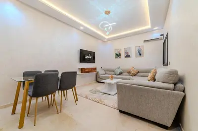a living room with a couch and a table and chairs at Central Gueliz 2 min M Avenue Balcony Pool View in Marrakech