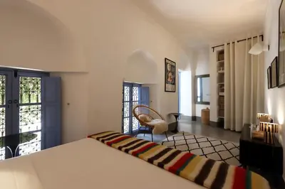 a bedroom with a bed and a chair in a room at mon riad in Marrakech