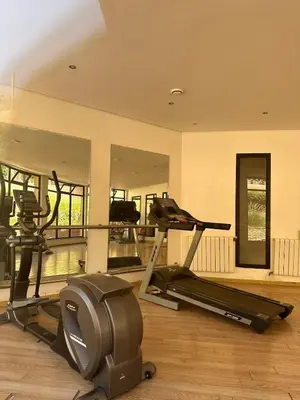 a gym with two exercise bikes and a mirror at Marrakech Oasis, Residence Ennaim 1 in Marrakech