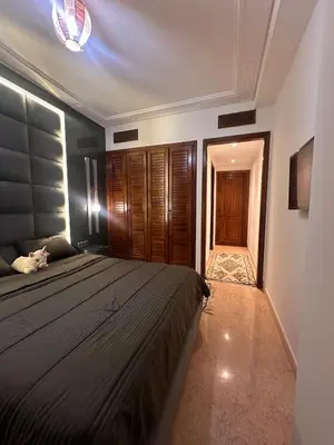 a bedroom with a large bed and a hallway at Marrakech Oasis, Residence Ennaim 1 in Marrakech