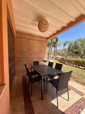 a patio with a table and chairs on a porch at Marrakech Oasis, Residence Ennaim 1 in Marrakech