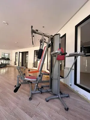 a gym with a treadmill and a chair in a room at Marrakech Oasis, Residence Ennaim 1 in Marrakech