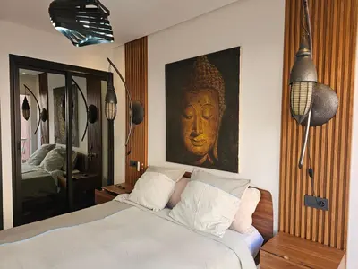 a bedroom with a bed with a large painting on the wall at Apparemment haut de gamme à l'hivernage in Marrakech