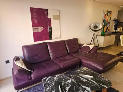 a living room with a purple leather couch at Apparemment haut de gamme à l'hivernage in Marrakech