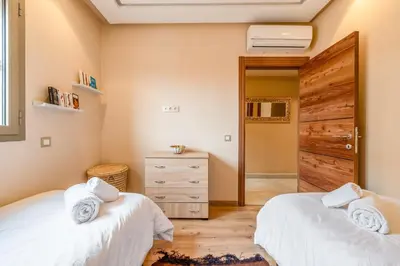 two twin beds in a room with a closet at Apartment center marrakech - Gueliz in Marrakech