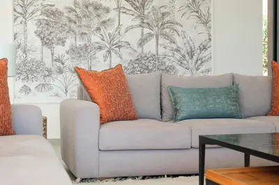 a living room with a gray couch with orange and blue pillows at La Salea - Golf Amelkis in Marrakech