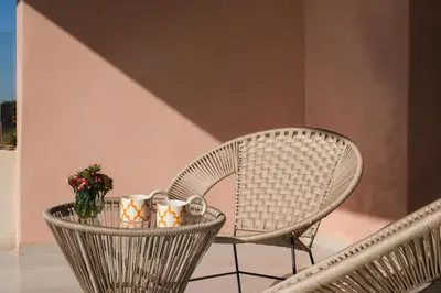 two wicker chairs and a table with cups and flowers at La Salea - Golf Amelkis in Marrakech
