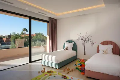 a bedroom with two beds and a large window at La Salea - Golf Amelkis in Marrakech