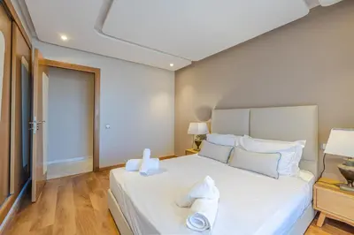 a bedroom with a large white bed with towels on it at Luxueux appartement à Riad Garden in Marrakech