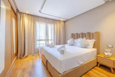 a bedroom with a large bed with a large window at Luxueux appartement à Riad Garden in Marrakech
