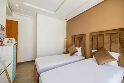 two beds in a hotel room with white sheets at Cozy & Elegant appart in hypercenter of Marrakech in Marrakech