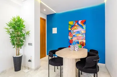 a dining room with a blue wall and a table and chairs at Cozy & Elegant appart in hypercenter of Marrakech in Marrakech