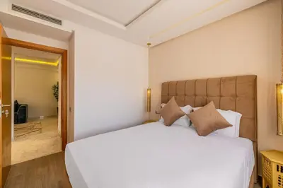 a bedroom with a large white bed with pillows at Cozy & Elegant appart in hypercenter of Marrakech in Marrakech