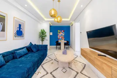 a living room with a blue couch and a table at Cozy & Elegant appart in hypercenter of Marrakech in Marrakech