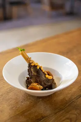 a white plate with a piece of meat on a table at Radisson Blu Marrakech, Carré Eden in Marrakech