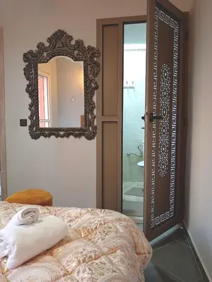 a mirror sitting on the wall next to a bed at Airport Menara Appartment in Marrakech
