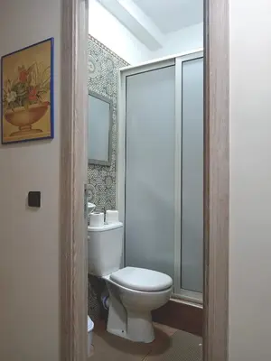 a bathroom with a toilet and a glass shower at Airport Menara Appartment in Marrakech
