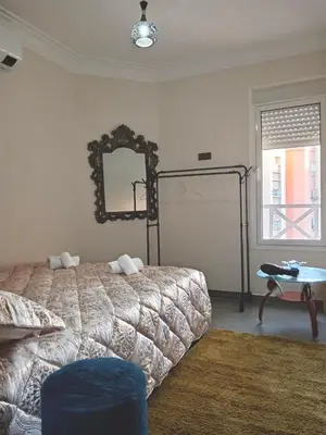 a bedroom with a bed and a mirror on the wall at Airport Menara Appartment in Marrakech