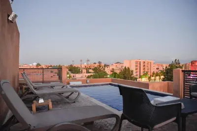 a balcony with a swimming pool on top of a building at Chic & Modern in City Center - Pool, IPTV & Comfort in Marrakech