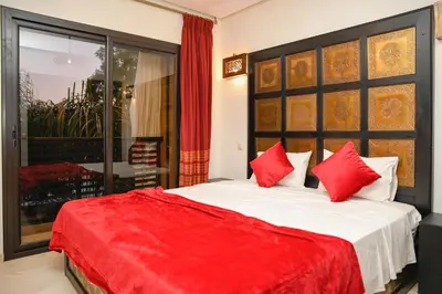 a bedroom with a large bed with red pillows at Chic & Modern in City Center - Pool, IPTV & Comfort in Marrakech
