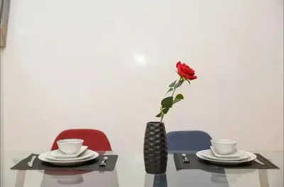 a rose in a vase on a table with two chairs at Chic & Modern in City Center - Pool, IPTV & Comfort in Marrakech