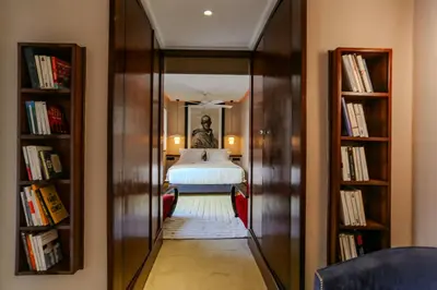a hallway with a bed in a room with books at Riad KO Nova in Marrakech