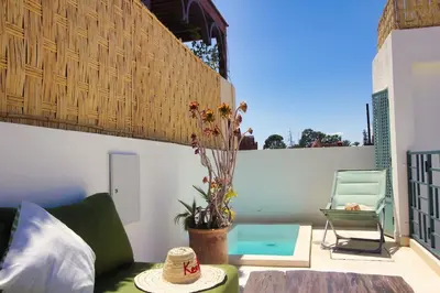 a living room with a green couch and a chair at Riad rooftop, pool and stunning view in Marrakech