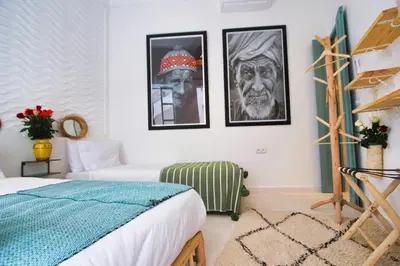 a bedroom with two beds and pictures on the wall at Riad rooftop, pool and stunning view in Marrakech