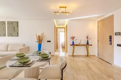 a dining room and living room with a table and chairs at Elegant 2BR apartment in Gueliz in Marrakech