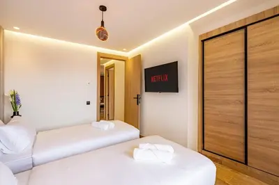 two beds in a room with a tv on the wall at Elegant 2BR apartment in Gueliz in Marrakech