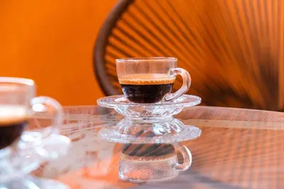 a glass cup of coffee on a glass table at New! Apartment Gueliz 2 min M Avenue with Pool and 24h Security & Parking in Marrakech