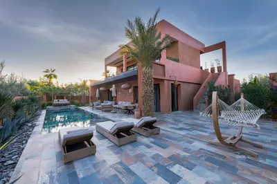 a house with a pool and a hammock and a house at Villa luxe Dar Paumar, Marrakech in Marrakech