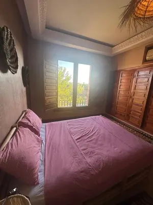 a bedroom with a bed with a pink bedspread and a window at Magnifique Riad, Élégance et Charme Authentique à Marrakech in Marrakech