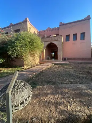 a building with a gate and a building with a yard at Magnifique Riad, Élégance et Charme Authentique à Marrakech in Marrakech