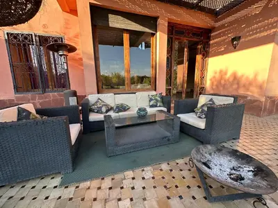a patio with a couch and chairs and a table at Magnifique Riad, Élégance et Charme Authentique à Marrakech in Marrakech