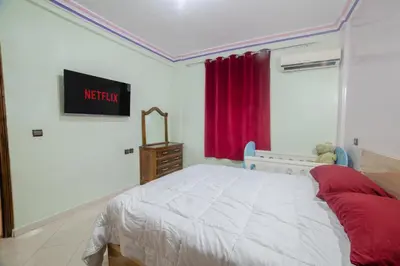 a bedroom with a bed and a tv on the wall at Family Apartment in Marrakech 3 Bedrooms & Balcony with View in Marrakech
