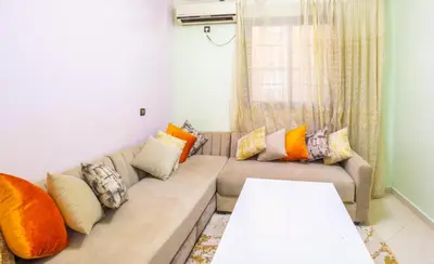 a living room with a couch with colorful pillows at Family Apartment in Marrakech 3 Bedrooms & Balcony with View in Marrakech