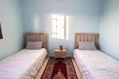 a room with two beds and a table in it at Family Apartment in Marrakech 3 Bedrooms & Balcony with View in Marrakech