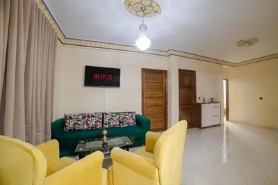 a living room with a green couch and yellow chairs at Family Apartment in Marrakech 3 Bedrooms & Balcony with View in Marrakech