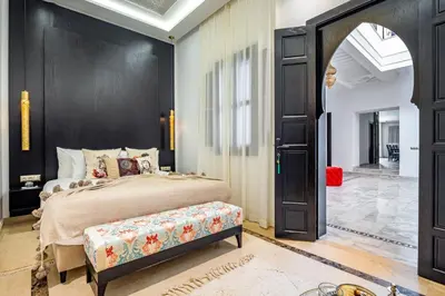 a bedroom with a bed and a black door at Riad N5 in Marrakech