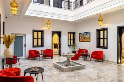 a lobby with red chairs and a fountain at Riad N5 in Marrakech