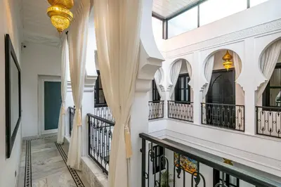 a corridor of a building with white walls and windows at Riad N5 in Marrakech