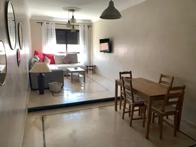 a living room with a table and chairs and a couch at Superb Location in Marrakech in Marrakech