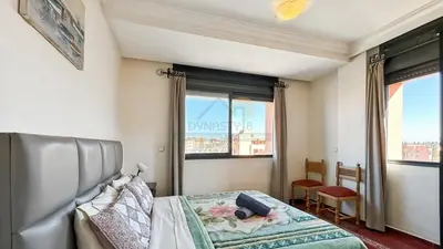 a bedroom with a bed and two windows at Appartement charmant à Guéliz in Marrakech