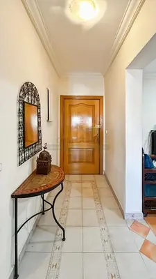 a hallway with a table and a wooden door at Appartement charmant à Guéliz in Marrakech